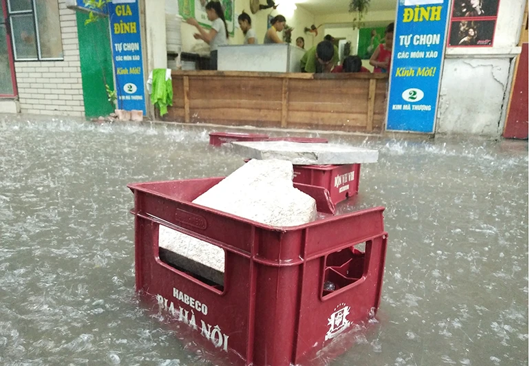 Ảnh: Quán xá đóng cửa, nước mưa chảy ngập nhà dân ở Hà Nội