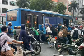 Hơn chục người nâng xe buýt cứu nữ tài xế mắc kẹt dưới gầm