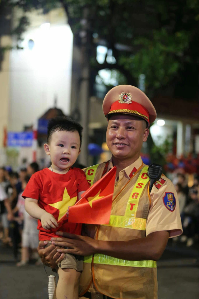 Khoảnh khắc tuyệt đẹp, ấm tình của một chiến sĩ cảnh sát và em bé đi xem tổng duyệt A80. Hình ảnh được chụp tại Tôn Đức Thắng - Nguyễn Thái Học. 17.jpg