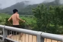 Người đàn ông trèo lan can cầu, nhảy xuống dòng nước lũ chảy xiết