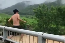Người đàn ông trèo lan can cầu, nhảy xuống dòng nước lũ chảy xiết