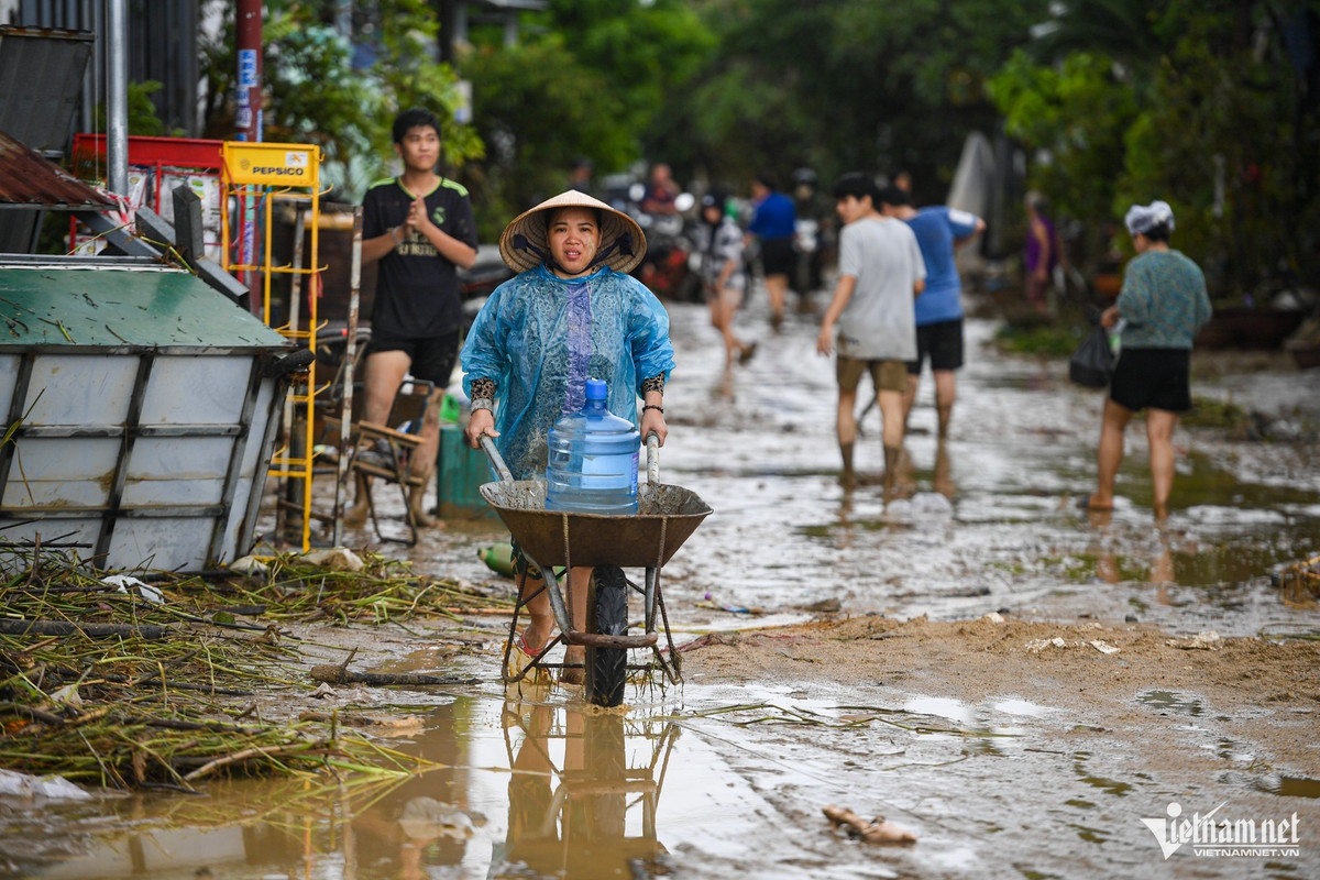 Sau nhiều ngày lũ lớn, nước rút để lại bùn đất ngập từ trong nhà ra ngoài đường, người dân vất vả dọn dẹp để sớm ổn định cuộc sống.