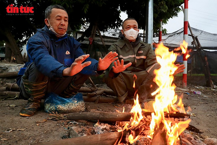Giữa mưa rét, có lúc người nông dân phải đốt lửa sưởi ấm đôi tay sau nhiều giờ làm việc.