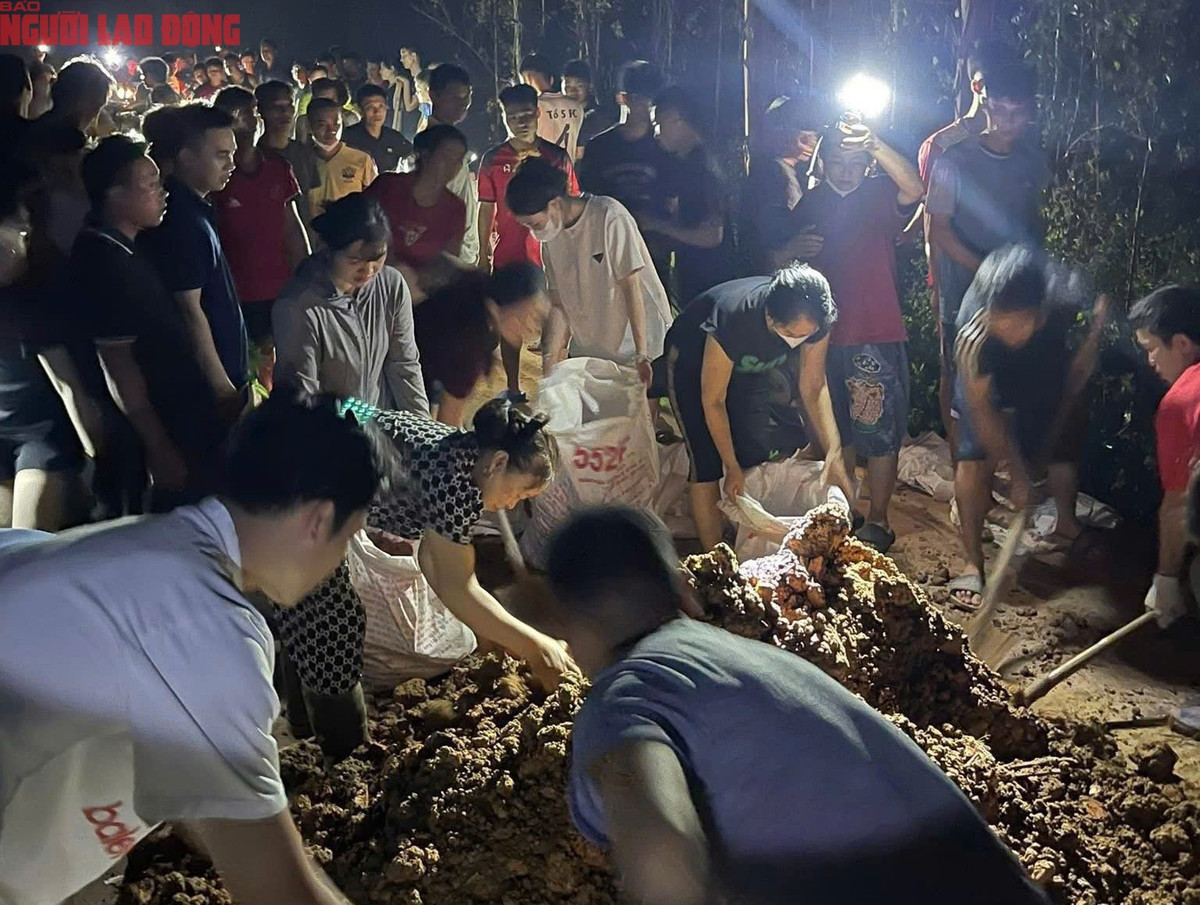 Giữa đêm khuya, người dân các thôn của xã Mỹ Thái cùng lực lượng hỗ trợ vẫn đang nỗ lực gia cố, quyết tâm giữ đê. Ảnh: Hoàng Thành