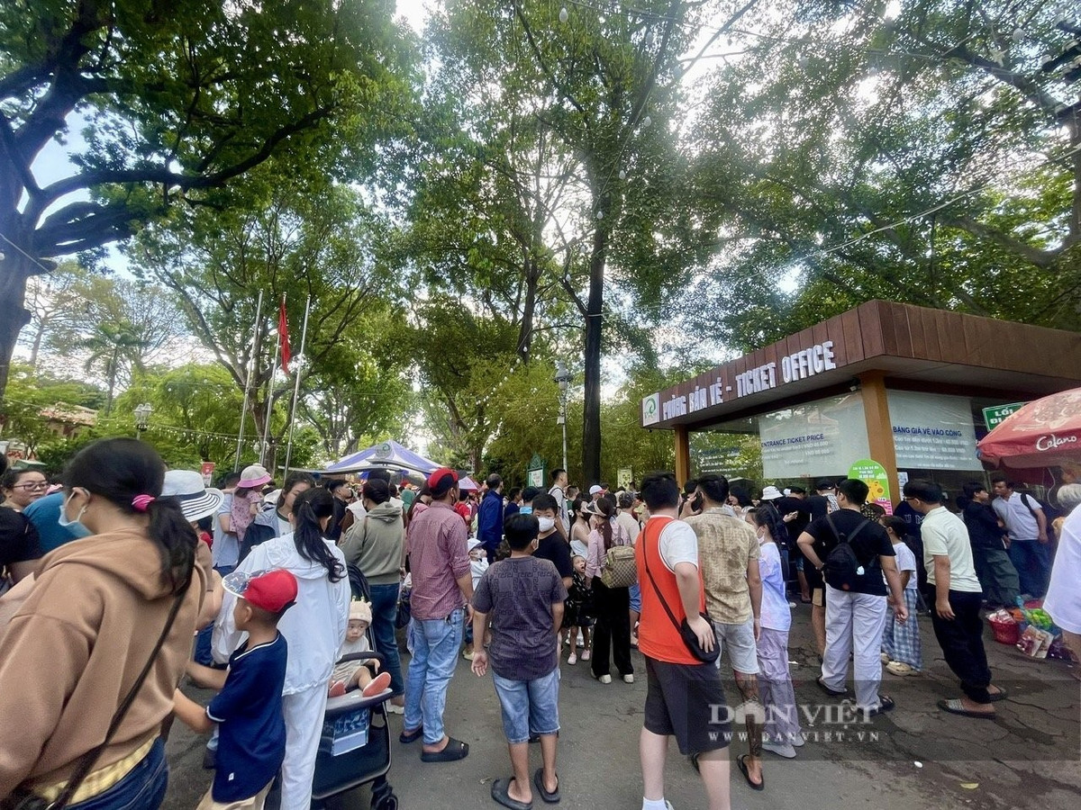 Tại quầy bán vé, rất đông người lớn và trẻ em đứng xếp hàng.