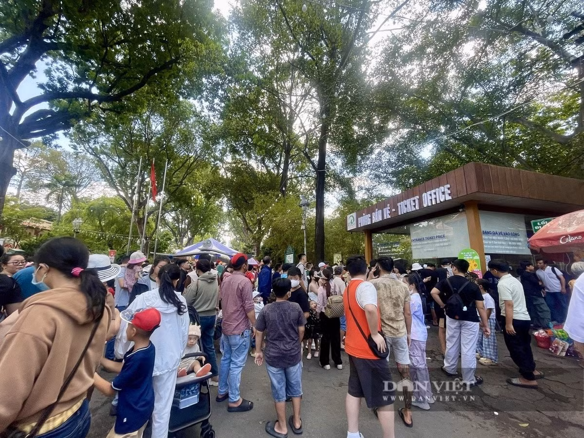 Tại quầy bán vé, rất đông người lớn và trẻ em đứng xếp hàng.