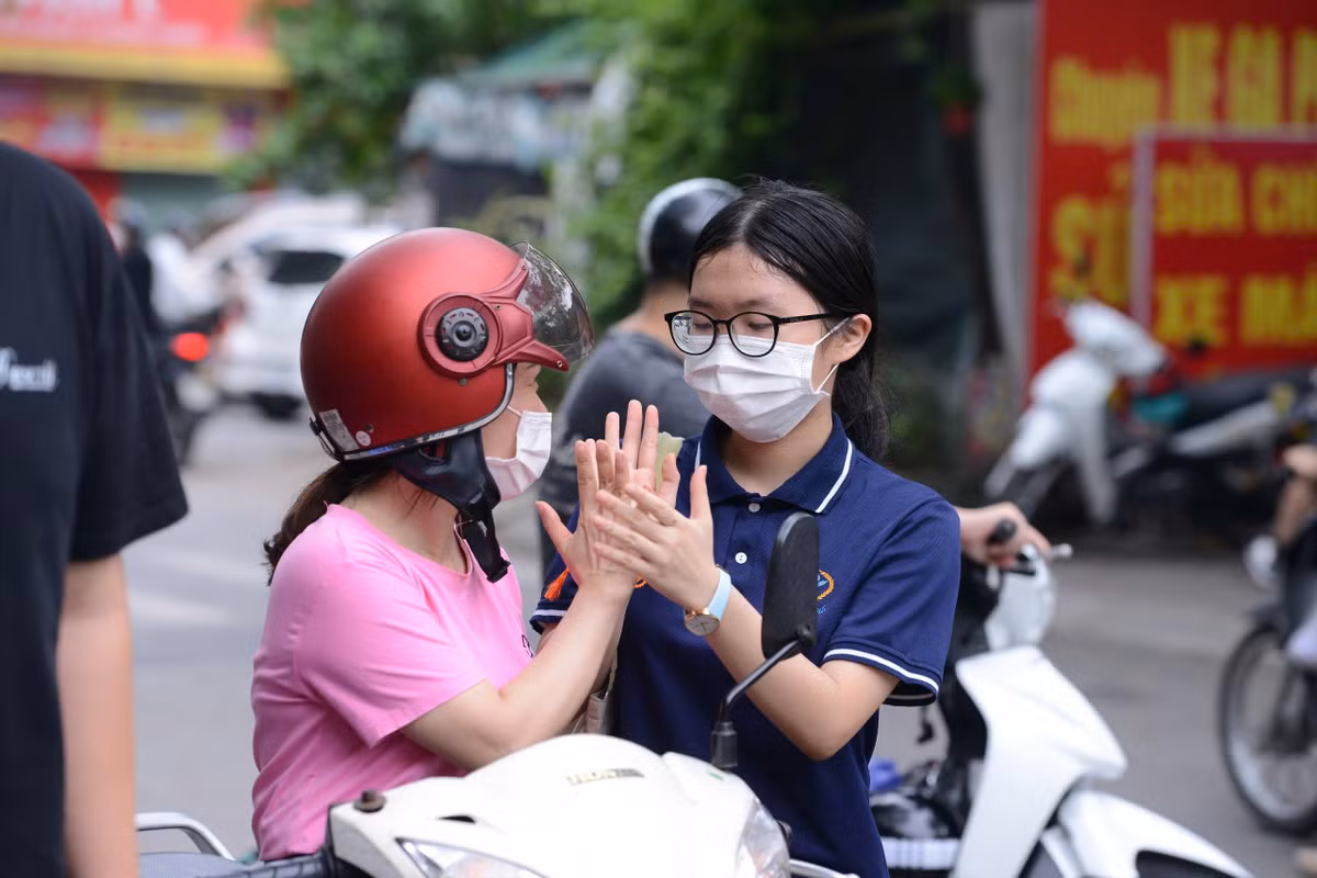 Phụ huynh động viên, khích lệ con trước khi bước vào môn thi cuối cùng.