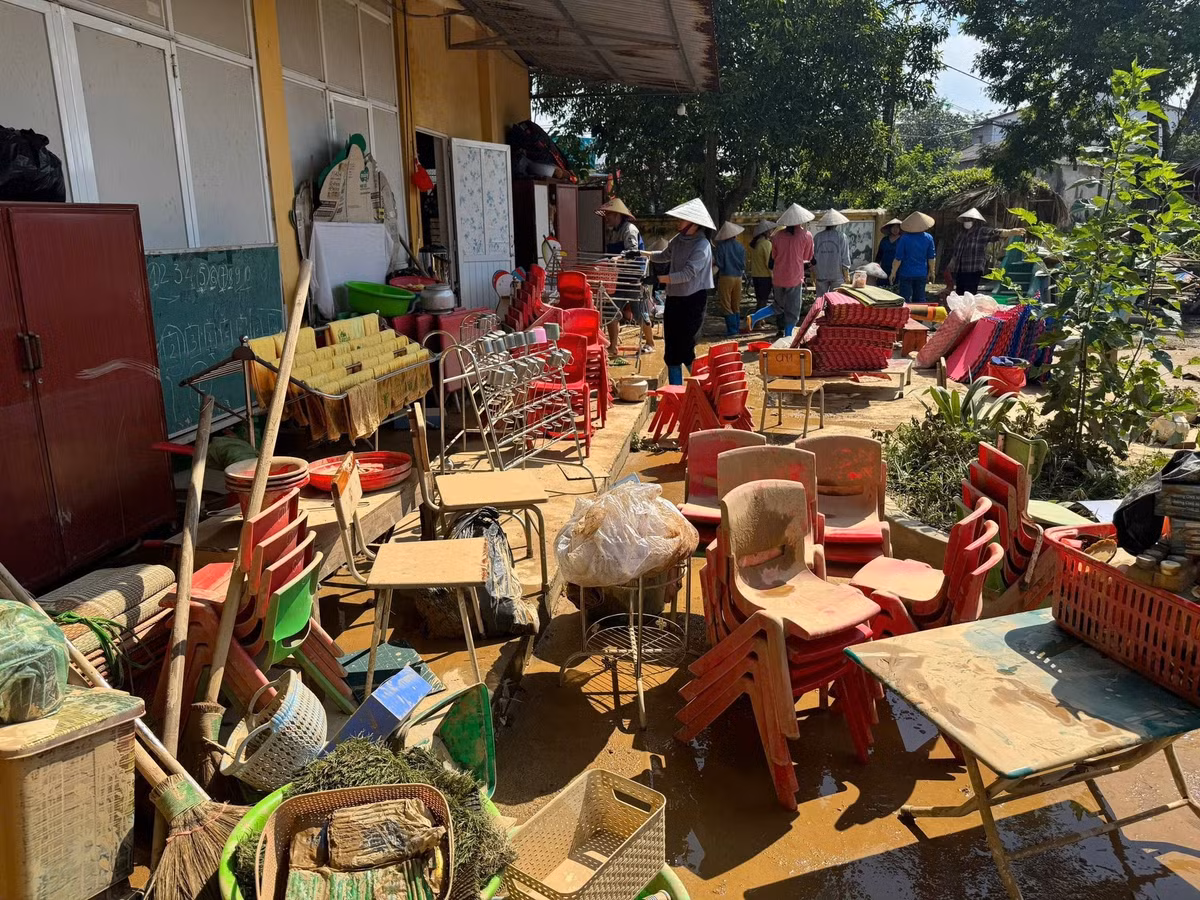 Trường Mầm non Huống Thượng cũng ngập trong biển nước. Các phòng học, thiết bị và đồ dùng dạy học bị hư hỏng. Lớp bùn non quánh đặc bám chặt lấy sàn nhà, sân trường và mọi vật dụng. Bàn ghế, giáo cụ chồng chất, móp méo, bị hư hỏng, xếp ngổn ngang ngoài sân trường. Ảnh: FBNT.
