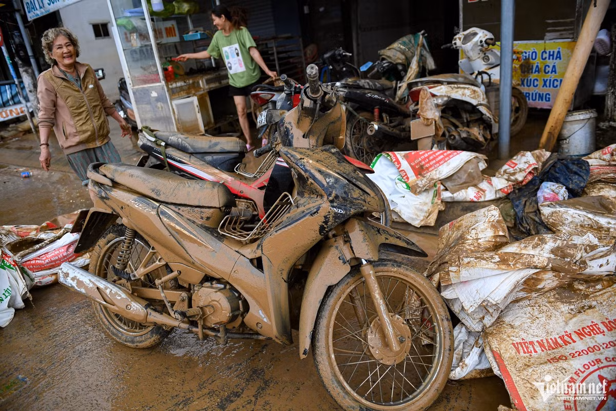 Trong những ngày lũ, 6 chiếc xe máy của gia đình bà Đặng Thị Âu bị ngập chìm, giờ bám đầy bùn đất. Gia đình phải kéo từng xe ra khỏi nhà chờ đi sửa, bởi ưu tiên lúc này là dọn dẹp nhà cửa, trong khi các cửa hàng sửa xe vẫn chưa hoạt động. Nước sạch đã có trở lại nhưng rất yếu, khiến việc rửa dọn càng khó khăn.