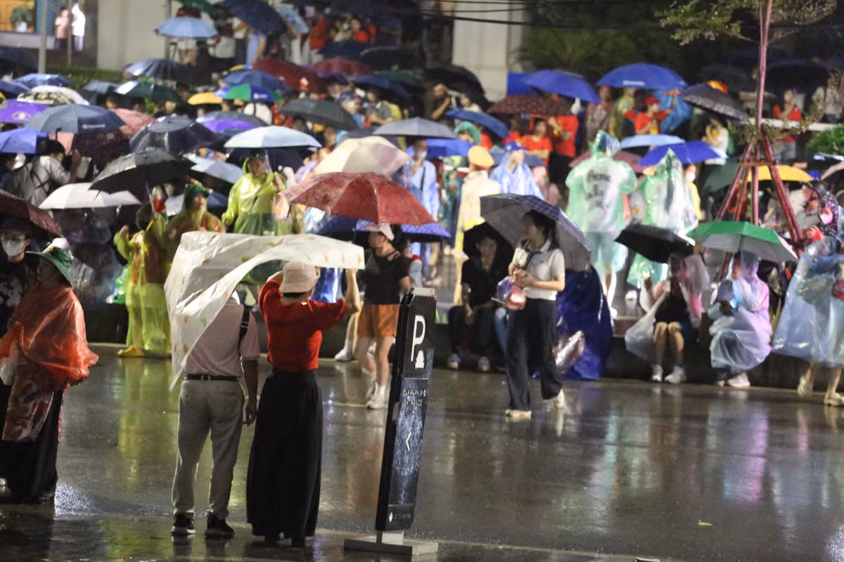 Mưa trút xuống càng thêm nặng hạt nhưng không vì thế mà làm giảm tinh thần "vượt nắng, thắng mưa" chờ xem diễu binh của người dân.