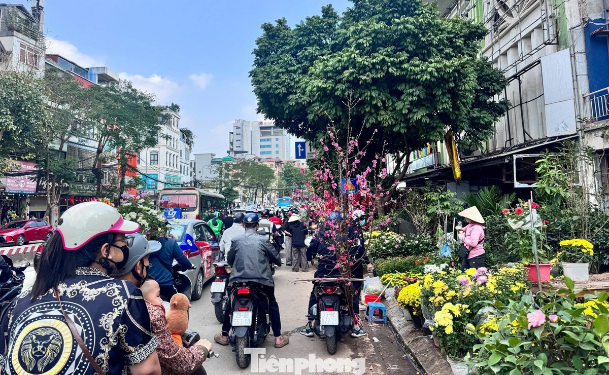 Trong ngày cuối năm, nhiều xe máy chở đào, quất nối đuôi rời chợ. Thay vì khung cảnh thưa thớt, năm nay các điểm bán hoa ghi nhận phiên giao dịch nhộn nhịp ngay trước giờ G.