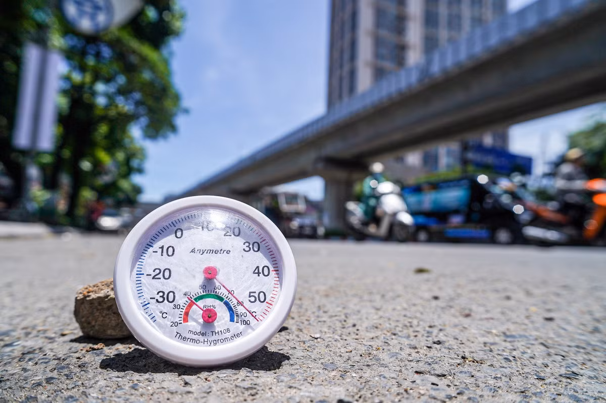 Lúc 12h, nhiệt độ ngoài trời tại Hà Nội là 37 độ C, nhưng nhiệt độ đo thực tế trên mặt đường vượt mức 50 độ C, cường độ ánh sáng rất mạnh.