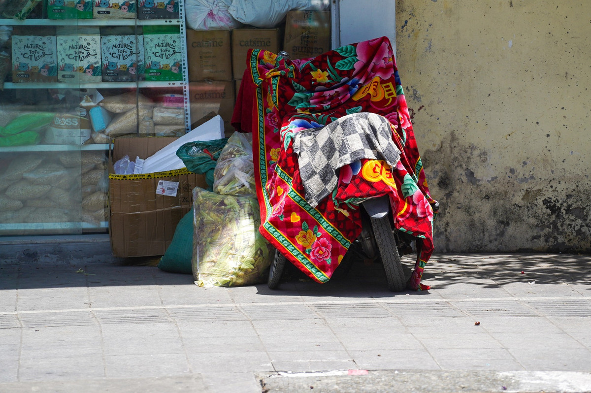 Người dân dùng cả chăn để bảo vệ xe máy.