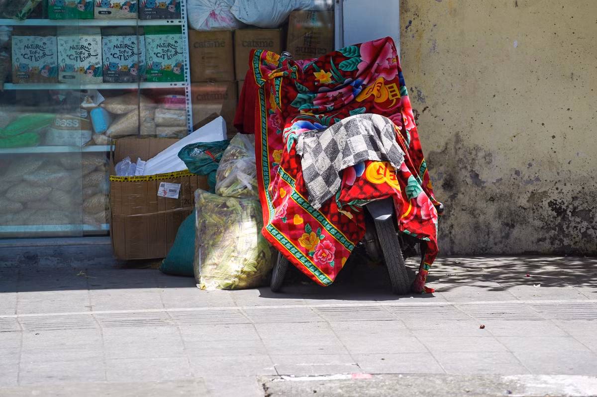 Người dân dùng cả chăn để bảo vệ xe máy.