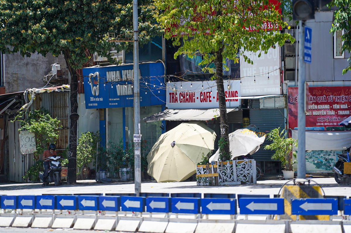 Nhiều hộ kinh doanh dựng dù cỡ lớn, phủ bạt che kín cả mặt tiền cửa hàng.