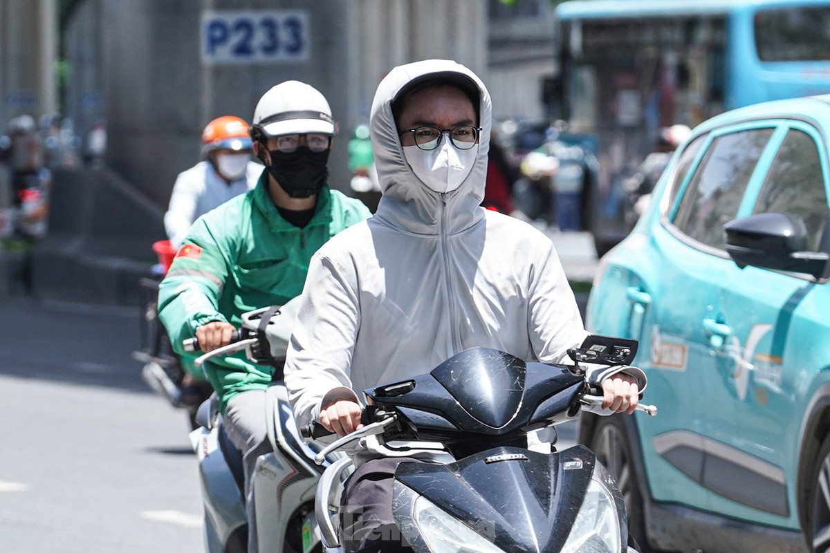 Để chống chọi với nắng nóng oi bức, người dân Thủ đô ra đường "trang bị" kín mít từ đầu đến chân bằng áo khoác, áo dài tay, áo chống nắng, khẩu trang...