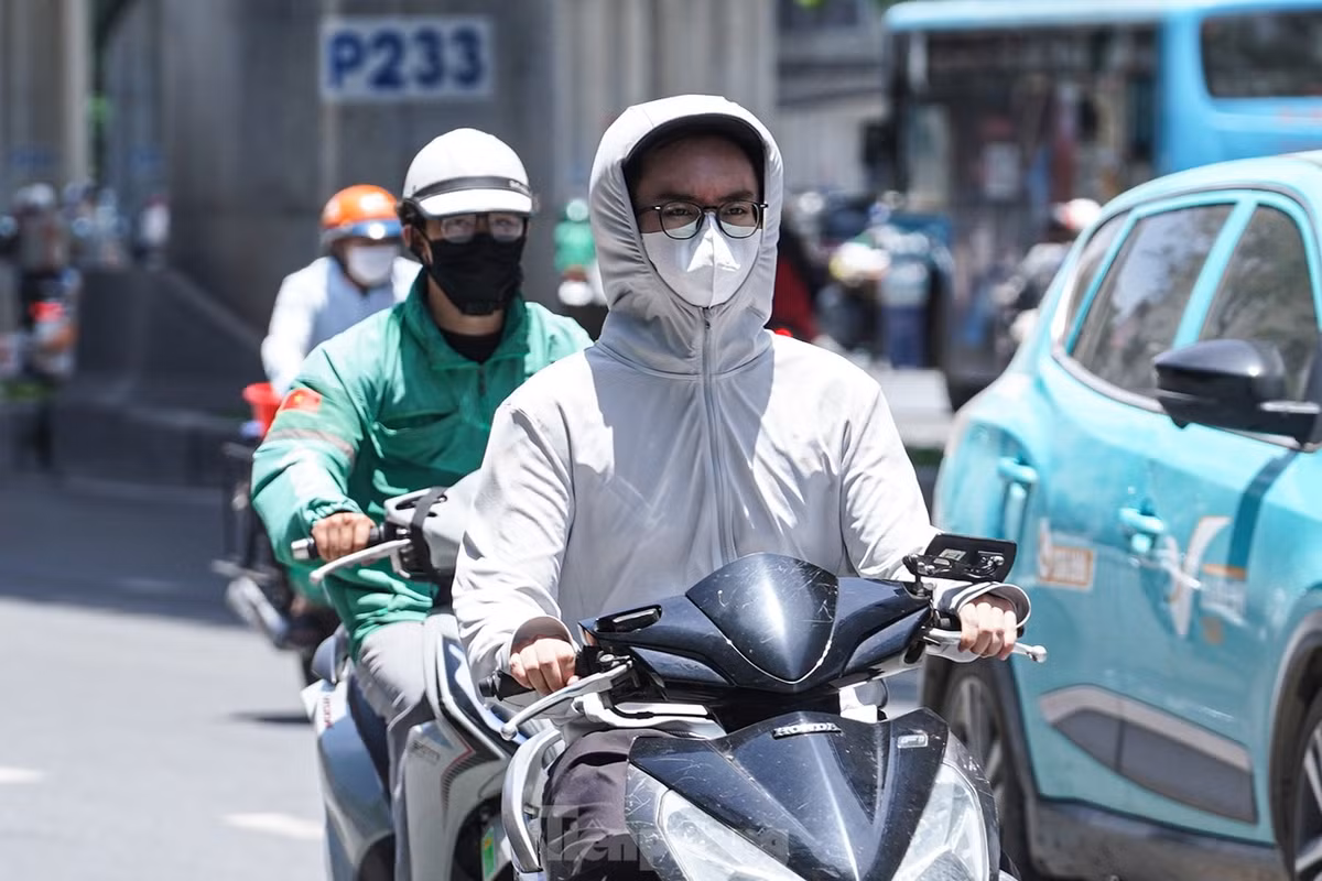Để chống chọi với nắng nóng oi bức, người dân Thủ đô ra đường "trang bị" kín mít từ đầu đến chân bằng áo khoác, áo dài tay, áo chống nắng, khẩu trang...