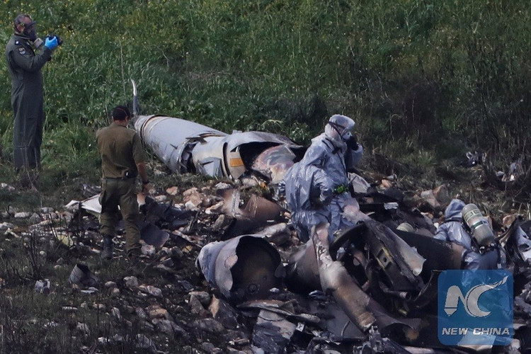 Lực lượng an ninh Israel đang kiểm tra phần còn lại của một máy bay chiến đấu F-16 của Không quân Israel, bị tên lửa phòng không của Syria bắn rơi gần làng Harduf, Israel ngày 10/2/2018. Ảnh Reuters 6.jpg