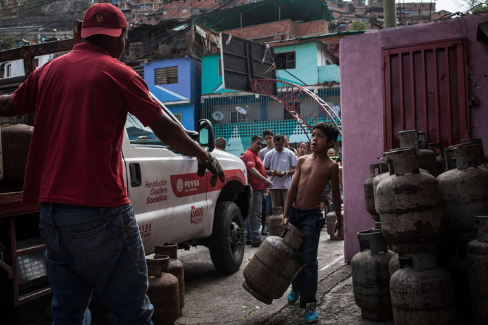 Một bé trai mang theo bình gas đã hết để mua bình gas mới ở khu ổ chuột Petare, Caracas, ngày 10/3/2017.