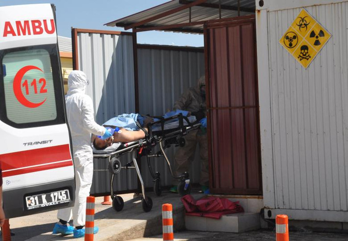 Người đàn ông Syria đến từ tỉnh Idlib được các nhân viên y tế Thổ Nhĩ Kỳ đưa tới bệnh viện ở thị trấn biên giới Reyhanli, tỉnh Hatay, Thổ Nhĩ Kỳ, ngày 4/4. Ảnh: Reuters.