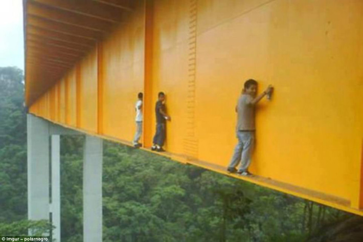 Các nghệ sĩ graffiti dường như đang “đùa với mạng sống” khi làm việc trên cây cầu Metlac ở Mexico. Ảnh: Daily Mail.