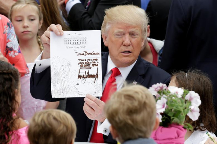 Tổng thống Trump cầm tấm thiệp chúc mừng lễ Phục sinh trên tay. Tấm thiệp này sau đó sẽ được gửi tới một thành viên trong quân đội.