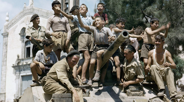 Những đứa trẻ địa phương trèo lên chiếc xe tăng Sherman ở Sicily (Italy) hồi tháng 8/1943. Ảnh: DM.