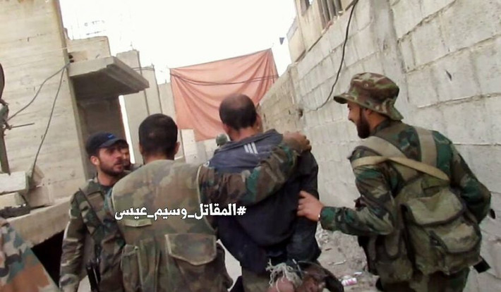 Một tay súng bị lực lượng Syria áp giải ở Qaboun. Ảnh: AMN.