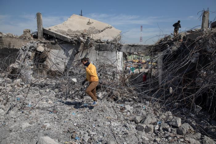 Một người dân đi qua ngôi nhà đổ nát ở Mosul hôm 17/4. Ảnh: Reuters.