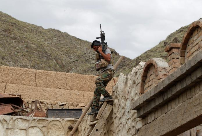 Một thành viên của Lực lượng đặc nhiệm Afghanistan đứng trên ngôi nhà từng được nhóm IS sử dụng ở quận Achin, tỉnh Nangarhar, ngày 23/4.