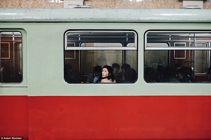 Người phụ nữ ngoái đầu nhìn ra ngoài cửa sổ khi ngồi trên tàu.