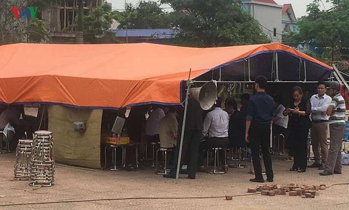 Tại một lều dã chiến được dựng trong sân nhà văn hóa thôn Hoành, ông Nguyễn Đức Chung cùng đại diện chính quyền, nhân dân ký nhận biên bản nhận các cán bộ, chiến sĩ bị giữ, cũng như ký nhận bản cam kết với xã Đồng Tâm.