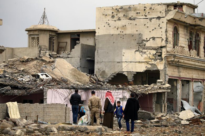 Một gia đình Iraq kiểm tra ngôi nhà bị hư hại.