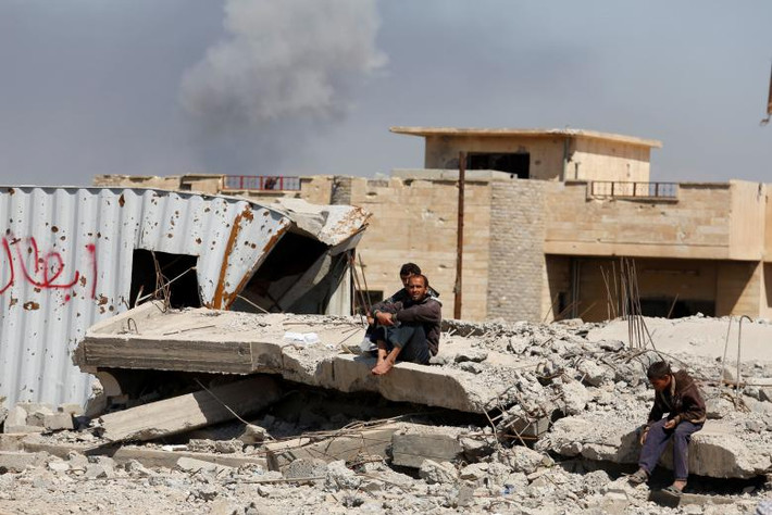 Những người dân Iraq chạy loạn chờ nhận thực phẩm được phân phát miễn phí ở Tây Mosul. (Nguồn ảnh: Reuters)