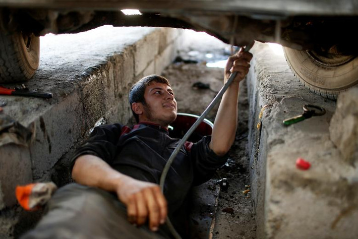 Người đàn ông Iraq đang sửa chữa ô tô ở Đông Mosul ngày 27/4. (Nguồn ảnh: Reuters)