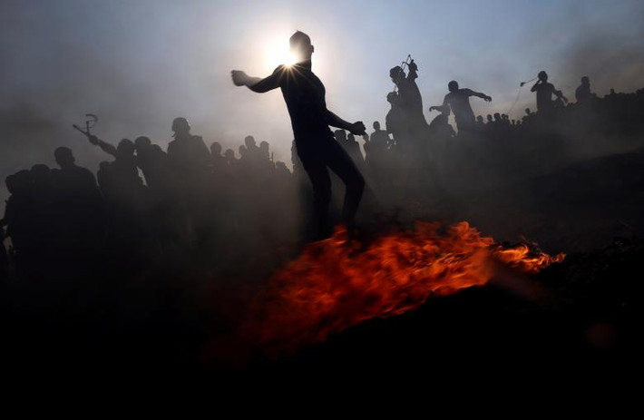 Người biểu tình Palestine ném đá vào các binh sĩ Israel trong cuộc biểu tình ở miền nam Dải Gaza ngày 24/8. Căng thẳng giữa Israel và Palestine vẫn tiếp diễn trong những tháng qua.