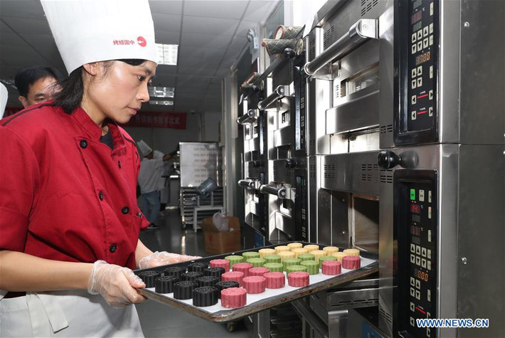 Nữ đầu bếp cho những chiếc bánh vào lò vi sóng trong công đoạn cuối cùng làm bánh.