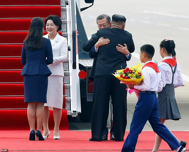 Bà Ri Sol-ju bắt tay Phu nhân Tổng thống thống Hàn Quốc Kim Jung-sook trong khi Tổng thống Moon Jae-in và Nhà lãnh đạo Triều Tiên Kim Jong-un có cái ôm nồng ấm. Ảnh: AP.