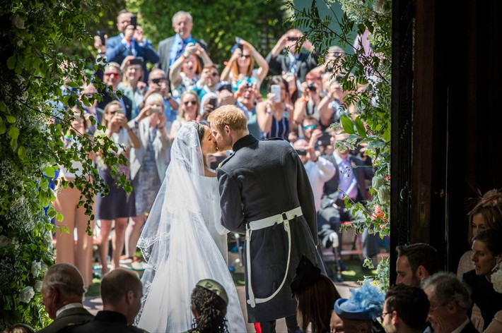 Bức ảnh chụp Hoàng tử Harry và cô dâu Meghan Markle trao nhau nụ hôn trong đám cưới của họ bên ngoài nhà nguyện St George ở Lâu đài Windsor ngày 19/5 là một trong những khoảnh khắc ấn tượng nhất của Hoàng gia Anh năm 2018. (Nguồn ảnh: Mirror).