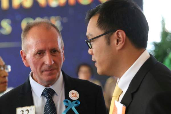 Chuyên gia về hang động người Anh Vernon Unsworth, trái, trò chuyện với một vị khách tại sự kiện. Ảnh: AP.