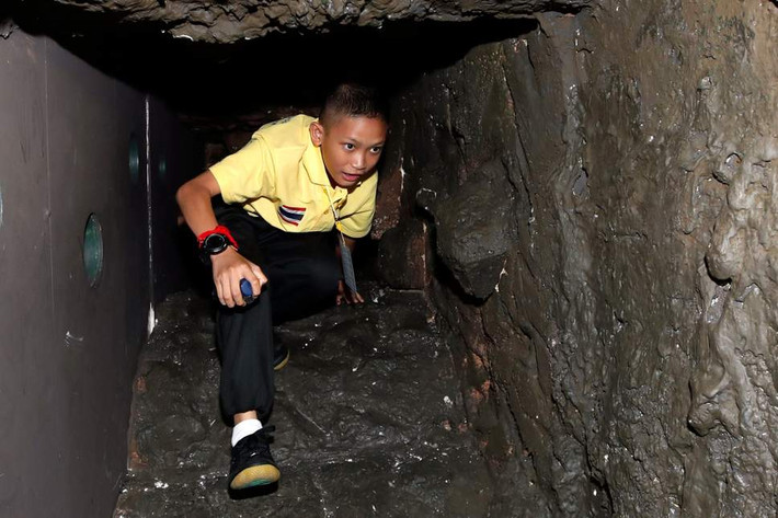 Trong ảnh là cầu thủ nhí Mongkol Boonpiam đang thực hiện phần thử thách đi qua mô hình hang động. Ảnh: EPA.