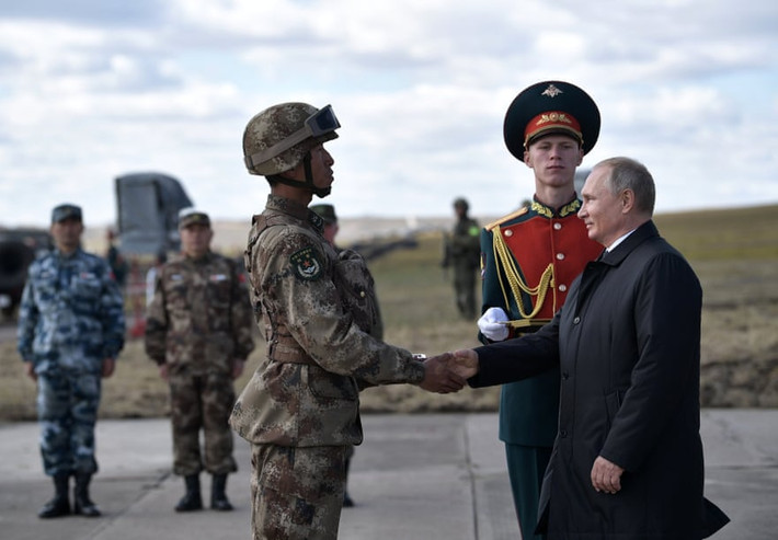 Tổng thống Putin cũng nhấn mạnh, Nga sẽ tiếp tục củng cố sức mạnh quân sự để bảo vệ chủ quyền đất nước cũng như để hỗ trợ các đồng minh. Ảnh: Tổng thống Putin bắt tay một binh sĩ Trung Quốc. Ảnh: AP.