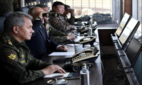 Tổng thống Putin dùng ống nhòm quan sát tại cuộc tập trận khi ngồi cạnh Bộ trưởng Quốc phòng Nga Shergei Shoigu. Ảnh: Reuters.