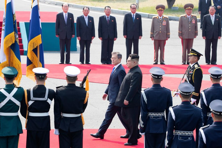Nhà lãnh đạo Kim Jong-un cùng Tổng thống Moon bước trên thảm đỏ trong lễ đón diễn ra tại làng đình chiến Bàn Môn Điếm phía Hàn Quốc. Ảnh: Getty.