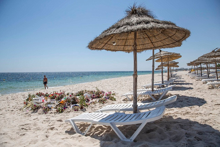 Các du khách Anh đặt hoa tưởng niệm trên bãi biển gần Sousse sau vụ xả súng khiến 38 người thiệt mạng và 36 người bị thương nặng năm 2015.