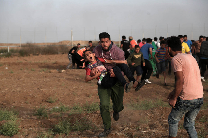 Một em nhỏ Palestine bị thương được đưa ra khỏi khu vực xung đột.