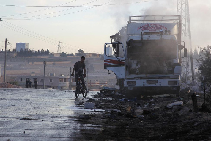 “Cuộc tấn công (nhằm vào đoàn xe cứu trợ Syria) là không thể chấp nhận được”, Chủ tịch Ủy ban Chữ thập đỏ quốc tế (ICRC) Peter Maurer cho biết. Ảnh: Một bé trai đi qua chiếc xe chở hàng viện trợ nhân đạo bị hư hại sau đợt không kích.