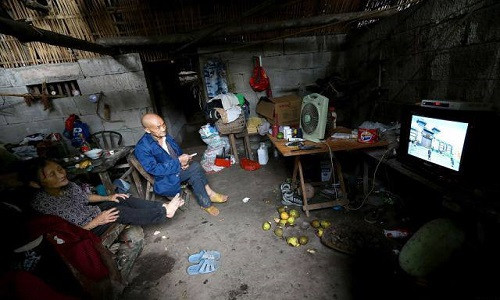 Vợ chồng cụ Liang ngồi xem TV trong hang động.