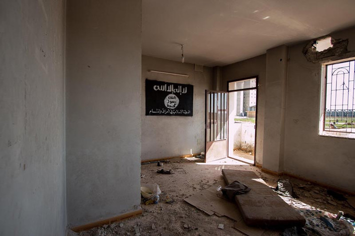 Một lá cờ của tổ chức khủng bố IS treo trên tường trong một tòa nhà bỏ hoang ở Tell Hamis, Syria, sau khi người Kurd giành lại quyền kiểm soát khu vực này từ tay nhóm khủng bố.