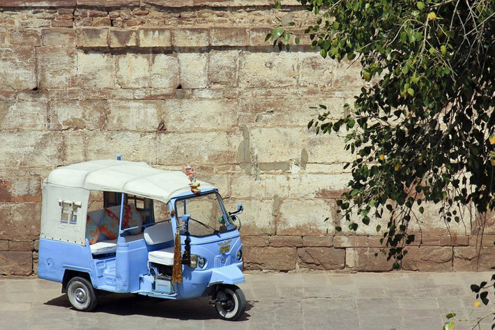 Chiếc xe tuk-tuk màu xanh được sử dụng để chở du khách trong thành phố.